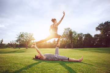 Fototapeta premium People practice acro yoga outdoors healthy lifestyle