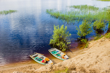 Two old blue boatslife jackets on a sandy beach with trees
