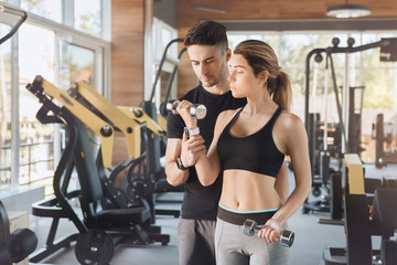 Fototapeta premium Young couple exercise together in gym healthy lifestyle