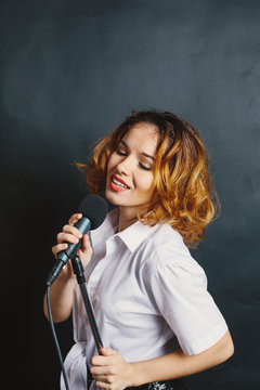 Studio portrait of a singing woman with microphone