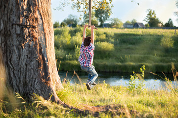 The boy is swinging on the swing