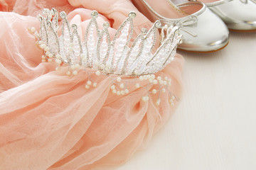 Vintage tulle pink chiffon dress, crown and silver shoes on wooden white floor © tomertu