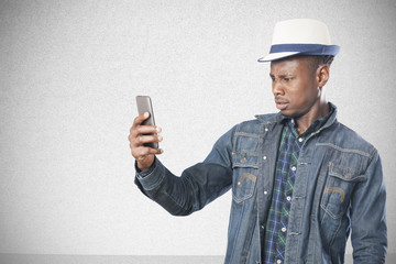 Portrait of a handsome young african man standing with a mobile phone