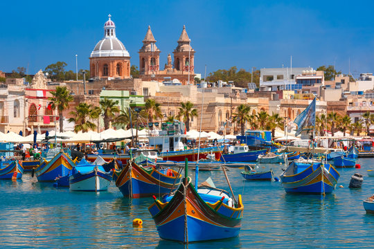 Fototapeta Traditional eyed colorful boats Luzzu in the Harbor of Mediterranean fishing village Marsaxlokk, Malta