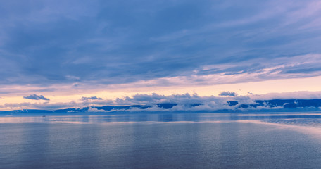 Fototapeta premium Sunset in the calmness on the lake and slowly floating boat