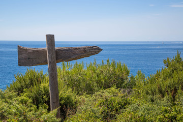 Wegweiser aus Holz hoch über dem Meer