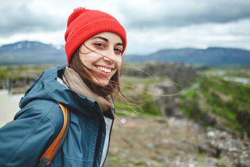 Naklejka premium Girl in warm clothing observing surroundings on background of mountains of Iceland.