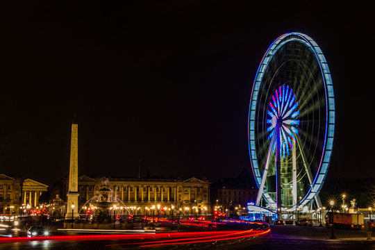 night in Paris with cars and ferris wheel spinning with car light trails