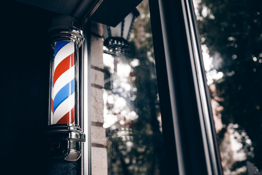 Barber shop pole at entrance of the window. background is dark. copyspace