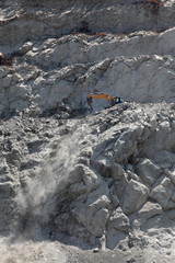 Stones digging using excavator at road construction site 