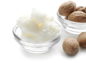 Shea butter and nuts in bowls on white background