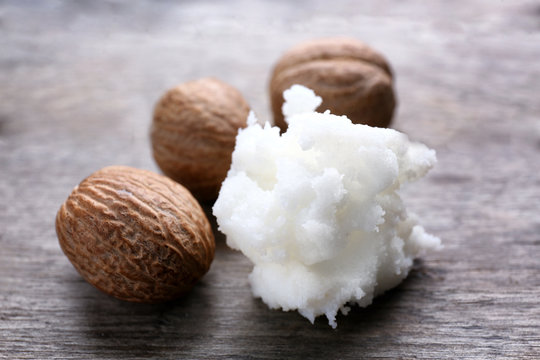 Shea butter and nuts on table