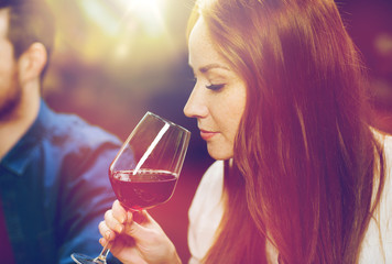 smiling woman drinking red wine at restaurant
