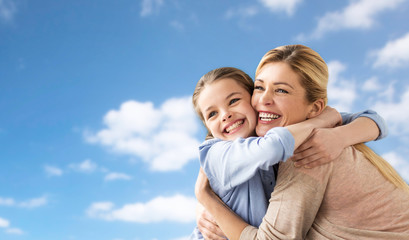 happy family of girl and mother hugging over sky