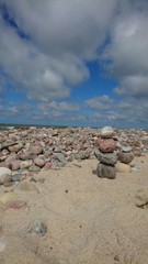 Fototapeta na wymiar Cloudy beautiful sky over beach with stones