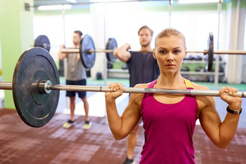 group of people training with barbells in gym