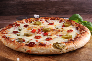 Hot pizza slice with melting cheese on a rustic wooden table. Italien food concept