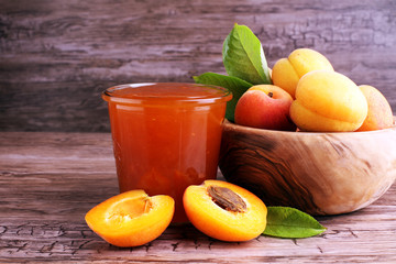 Apricot jam in glass bowl with fruit around