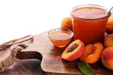 Apricot jam in glass bowl with fruit around