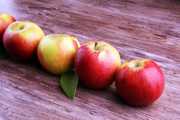 Ripe red apples on wooden background summer concept