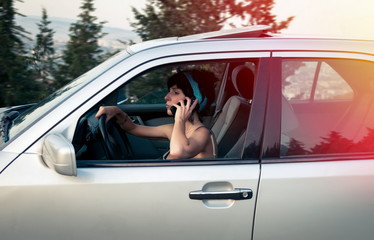 Pretty woman driving the car and talking on phone