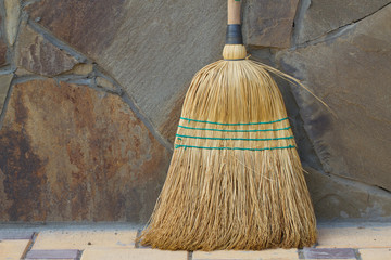 Broom on stone wall background