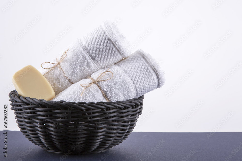 Wall mural two white towels in a black basket. the background is white.