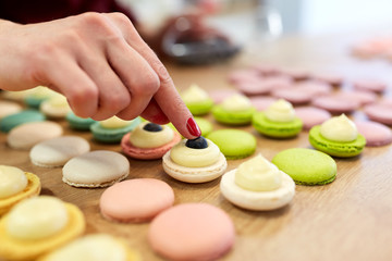 Obraz na płótnie Canvas chef decorating macarons shells at pastry shop