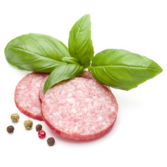 Salami smoked sausage three slices, basil leaves and peppercorns isolated on white background cutout