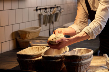 baker with dough rising in baskets at bakery