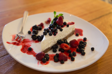 Berry cheesecake with berries on a plate in a caffe