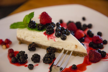 Berry cheesecake with berries on a plate in a caffe