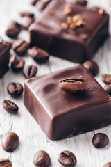Chocolate sweets with coffee beans on a wooden table