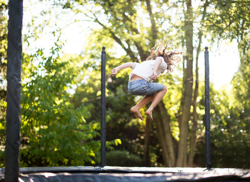 Full Length Of Girl Jumping On Trampoline At Park