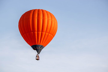 bright orange balloon flying in the blue sky