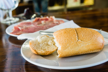 Freshly baked bread roll with Spanish ham (Jamón ibérico, Iberian ham, pata negra) cured ham served as a tapas