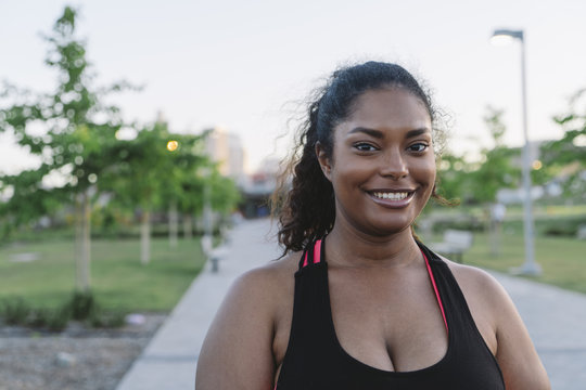 Portrait of happy sportswoman at park