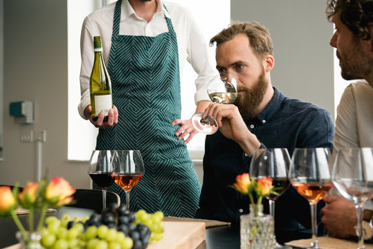 Bartender standing by customer tasting wine in tasting room