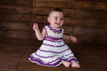 Beautiful girl in pink dress on a wooden background