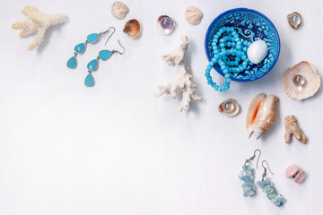 the white background on the marine theme with seashells, beads, corals and earrings