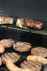 Hamburger, sausage and steak barbecued on the grill