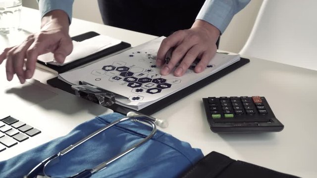 Healthcare costs and fees concept.Hand of smart doctor used a calculator for medical costs in modern hospital in 4K (UHD).