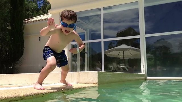 Boy jumping and diving in Swimming Pool -Slow Motion- Perfect for videos about: swimming, pools, summer fun, vacation, getaways, underwater footage, kids, beating the heat, and exercise.