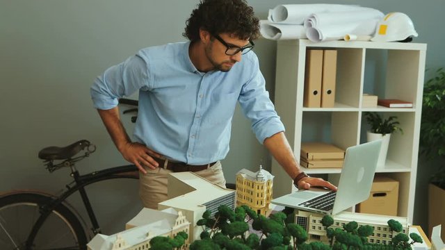 Attractive business man working in the laptop on his new architectural project in his office.