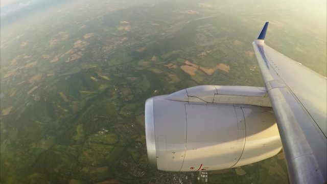 View from aircraft window of engine and England below