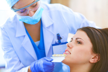 Woman dentist working at her patients teeth