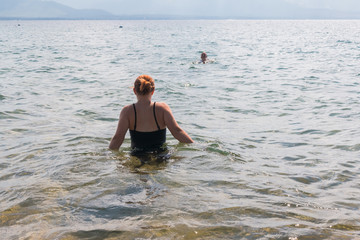 Girl With Raised Arms in the Water at the Beach