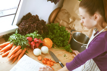Young woman cutting vegetables in the kitchen