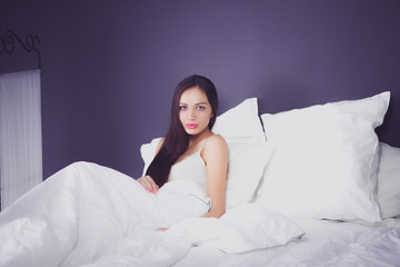 Obraz na płótnie Canvas Pretty woman lying in bed at home