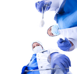 View from below of masked doctors looking at patient before surgery.